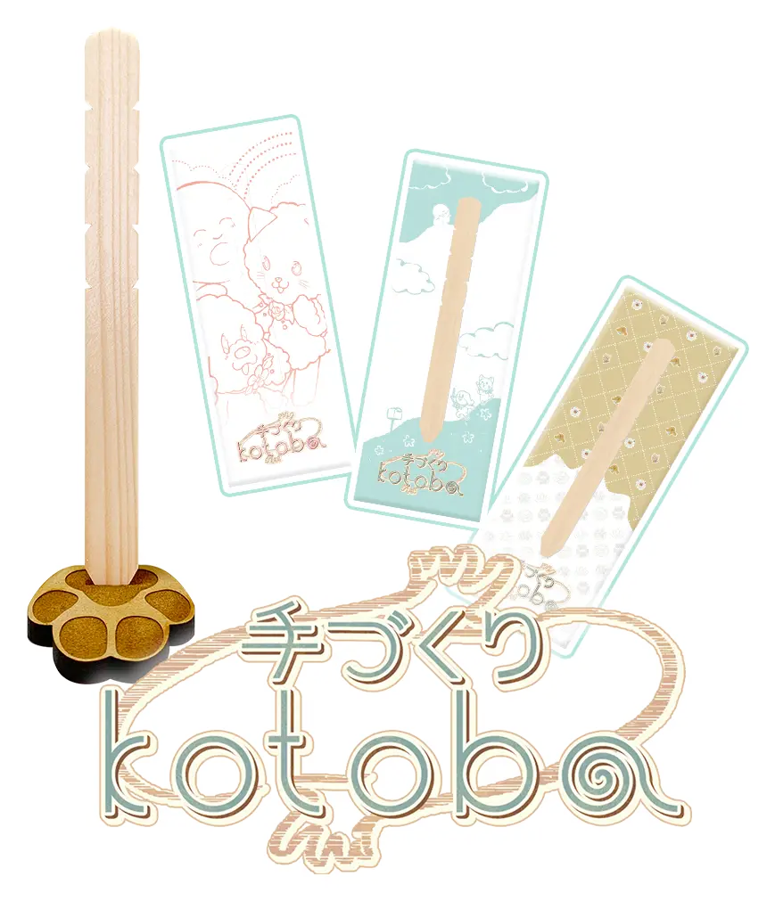 手づくりkotobaの商品画像です。本商品は塔婆をモチーフにした手のひらサイズの木の板に、板を立てるかわいい台座のセットとなっています。商品にはYoutubeで配信中のアニメ・「kotobaの森」公式キャラクターたちのパンフレットが、3種類の中から一つランダムでついてきます